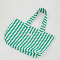 a green and white striped tote bag laying flat on a white background