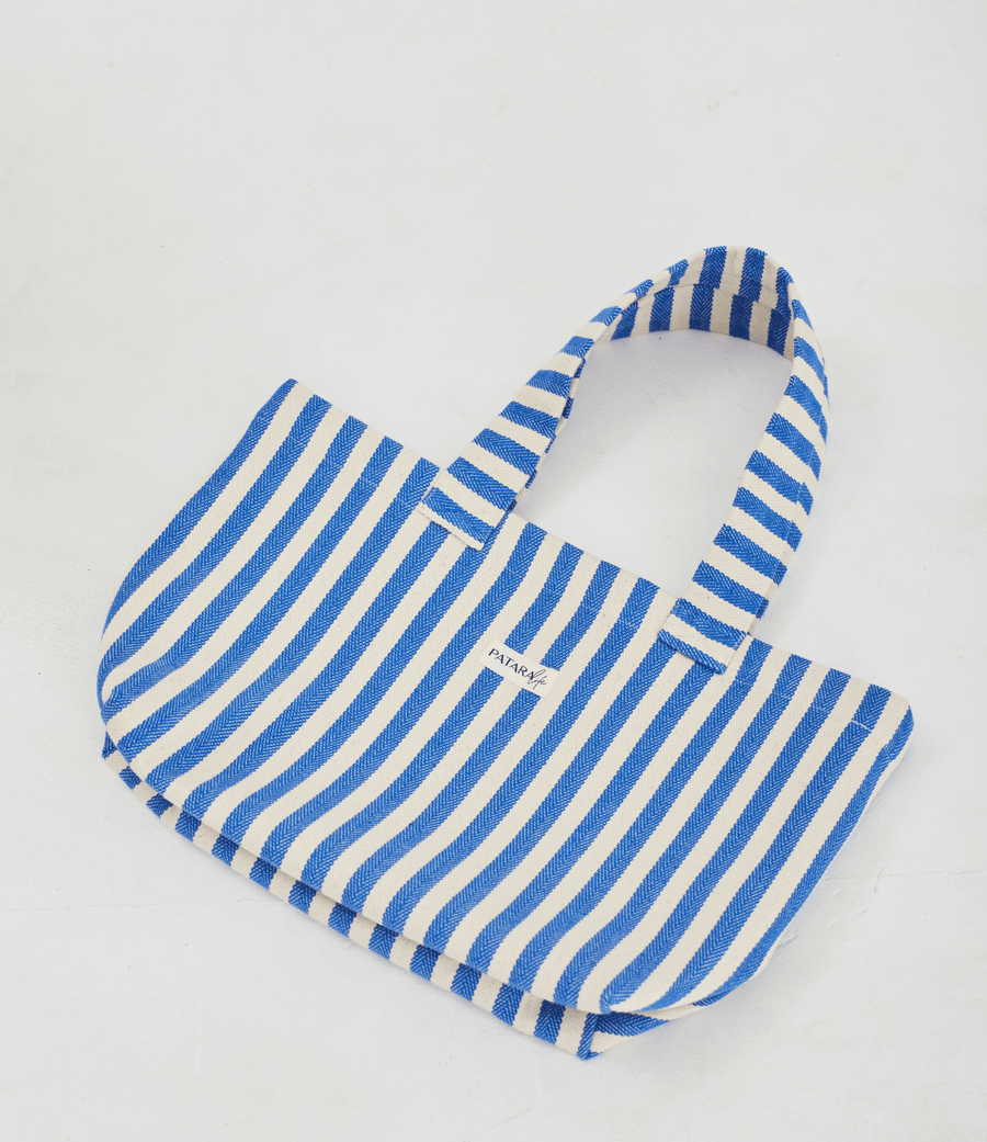 a blue and white striped tote bag laying flat on a white background