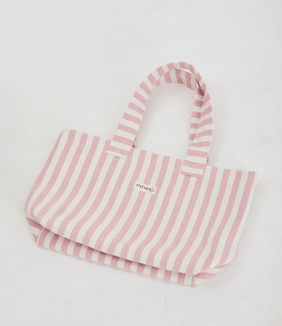 a light pink and white striped tote bag laying flat on a white background