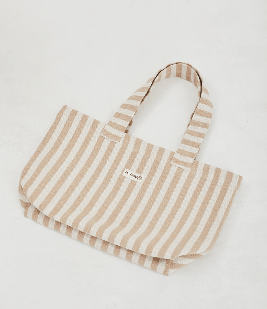 a light brown and white striped tote bag laying flat on a white background